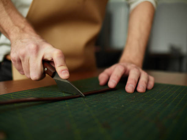istock Cutting the edge of the workpiece with a tailor knife. 940329886