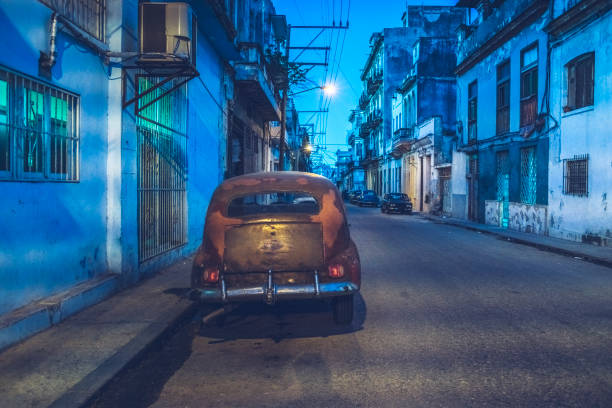 istock classical american car parked on Havana street at night 940340180