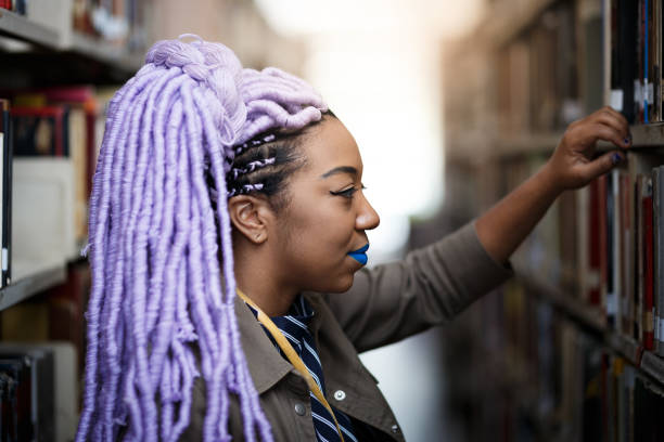 istock Black girl with dreadlocks in library 940348208