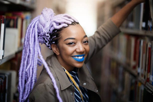 istock Black girl with dreadlocks in library 940348304