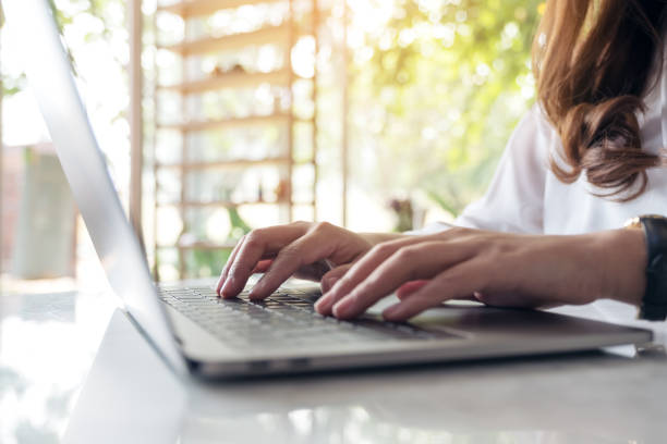 istock Closeup image of woman's hands working and typing on laptop keyboard on table with blur nature background 940348418