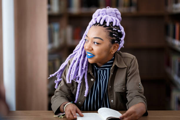 istock Black girl with dreadlocks in library 940348428