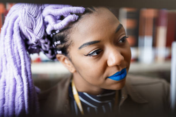 istock Black girl with dreadlocks in library 940348482