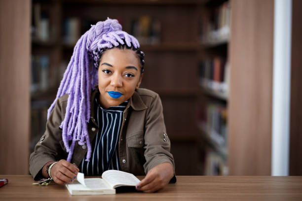 istock Black girl with dreadlocks in library 940348594