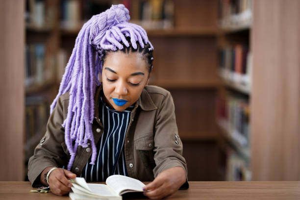 istock Black girl with dreadlocks in library 940348622