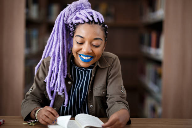 istock Black girl with dreadlocks in library 940348760