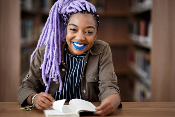 istock Black girl with dreadlocks in library 940348778