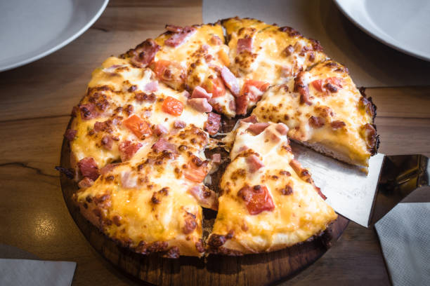 istock Hot Pizza slice ham and cheese with wood background. 940349024