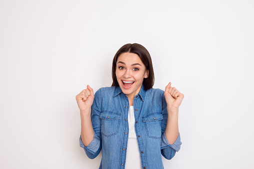 Portrait of excited young girl in jeans shirt opened mouth expressing happiness