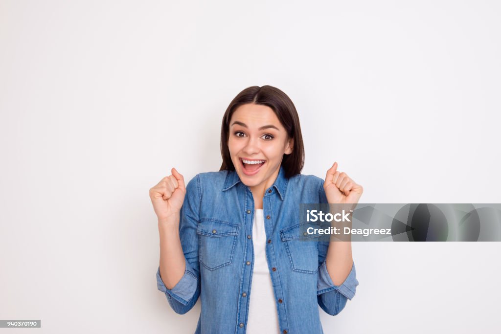 Portrait of excited young girl in jeans shirt opened mouth expressing happiness Women Stock Photo