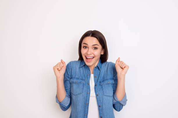 Portrait of excited young girl in jeans shirt opened mouth expressing happiness Portrait of excited young girl in jeans shirt opened mouth expressing happiness surprised woman stock pictures, royalty-free photos & images