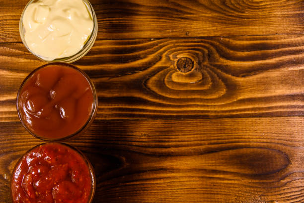 istock Different sauces in glass bowls on wooden table. Top view 940370338