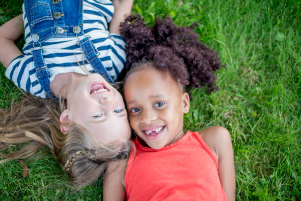 istock Girls Laying In The Grass 940373788