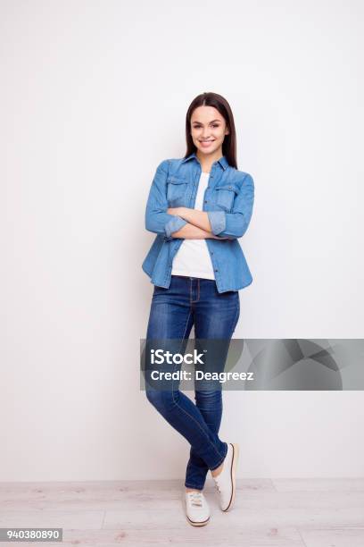 Pretty Young Woman In Jeans And Shirt Standing With Crossed Hands Against White Background Stock Photo - Download Image Now