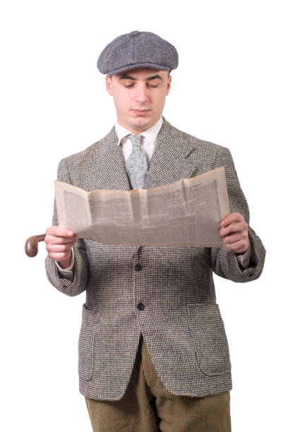 istock a young man in vintage clothes with hat, reading a newspaper, 1940 style 940385896