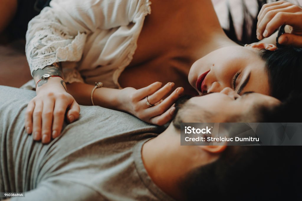 Couple laying on bed and hugging each other. Bed - Furniture Stock Photo