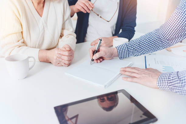 istock Professioanl real estate agent working with pleasant elderly couple 940391552