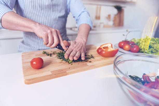 istock Pleasant man cutting vegetables for salad 940394906