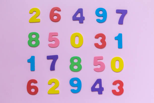 istock Multicolored wooden numbers texture on pastel rose background minimalistic concept. 940396226