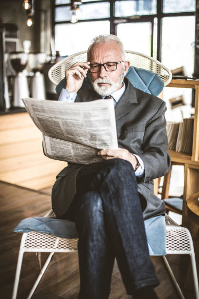 istock Senior businessman at his office riding newspapers . 940399496