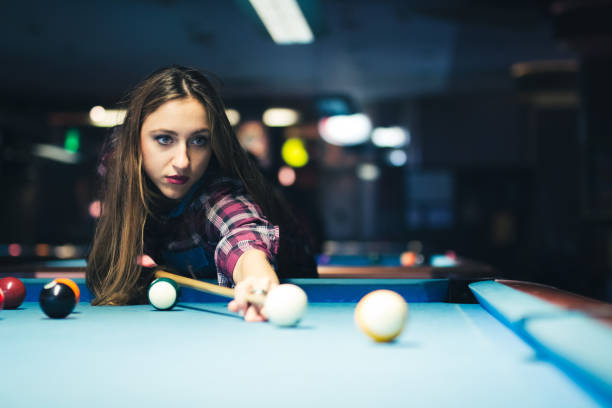 istock Young beautiful woman and plays billiard and have fun. 940411032