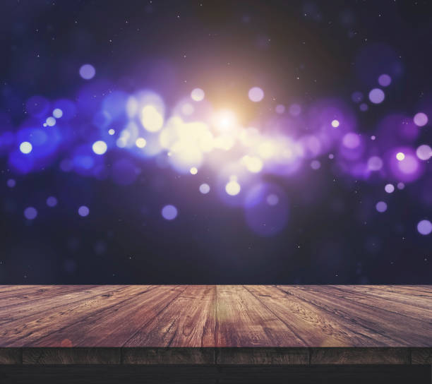 istock Wood table top with blurred light colourful bokeh abstract background 940413952