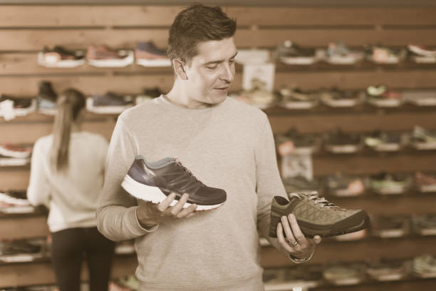 istock Nice man chooses shoes in shop 940415042