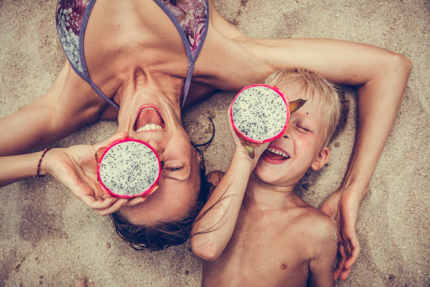 Happy  woman  and boy puts dragon fruit as glasses. Happy  woman  and boy puts dragon fruit as glasses. pitaya photos stock pictures, royalty-free photos & images