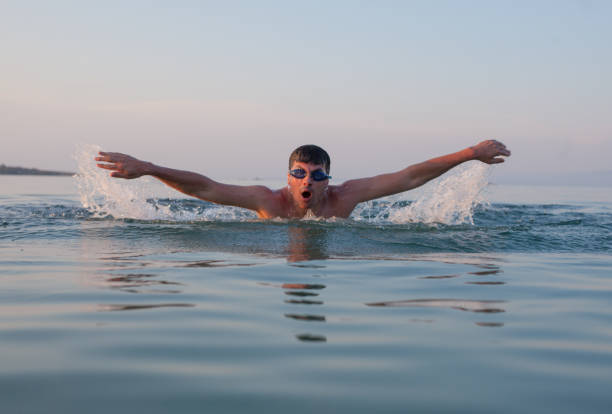 istock Man Swimming Sea Ocean Sunset 940429258