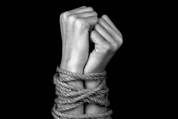hands tied with a rope hands tied with a rope close-up black background monochrome tying stock pictures, royalty-free photos & images