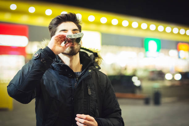 istock a young man with a hip flask on the street at night 940432932