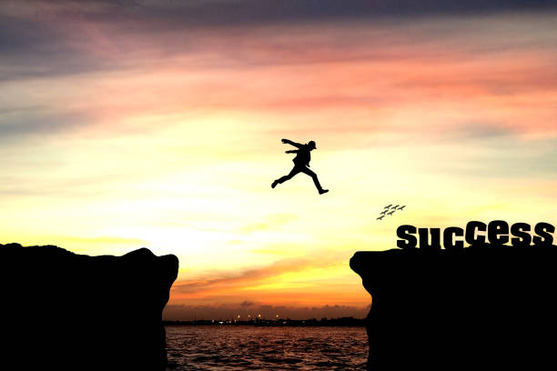 istock Silhouette of a man jumping over the cliff 940432938