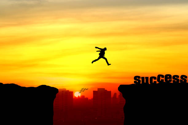 istock Silhouette of a man jumping over the cliff 940432972