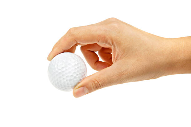 istock female hand holding golf ball isolated 940437704