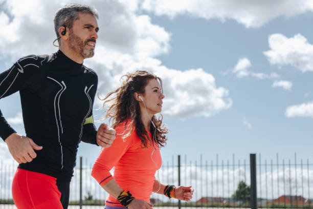 istock young adults couple running together 940438416