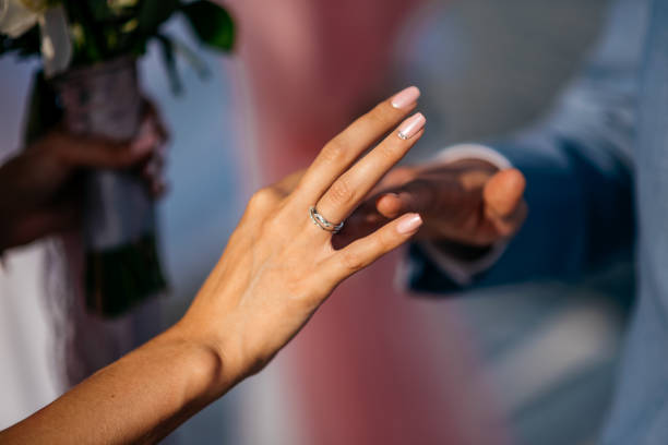 the groom puts the ring on the finger of the bride - passion women human hand macro imagens e fotografias de stock