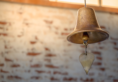 Old Brass Bell Hanging with White Brick Background