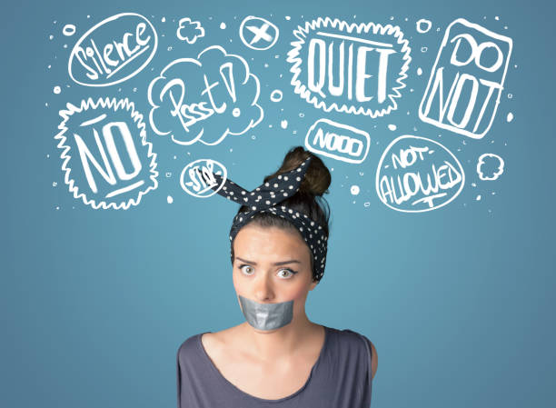 istock Young woman with glued mouth and thought clouds 940441616
