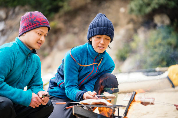 istock Two sea kayakers cooking and preparing lunch on a beach 940442080