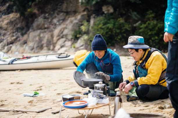 istock Two sea kayakers cooking and preparing lunch on a beach 940442108