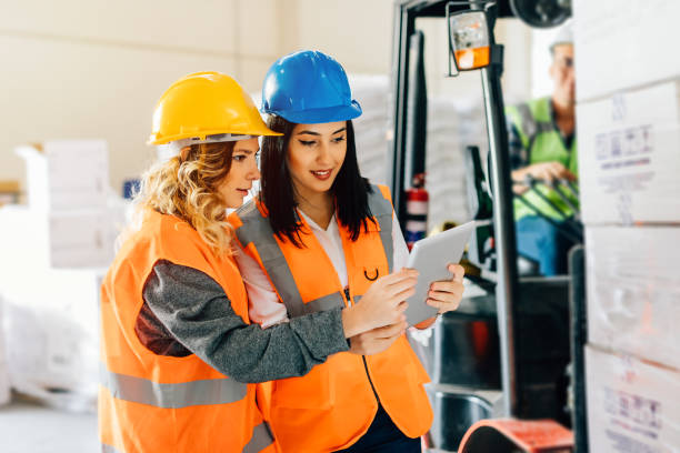 istock Female workers using a digital pc tablet in the factory warehouse 940446682