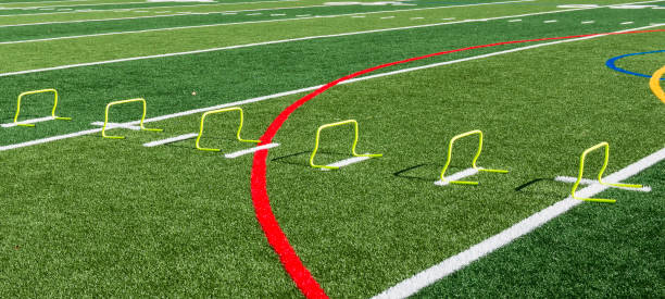 istock Yellow mini hurdles on green field 940446882