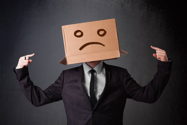 istock Businessman gesturing with cardboard box on his head with sad face 940449532