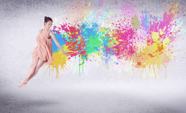 istock Modern street dancer jumping with colorful paint splashes 940450176