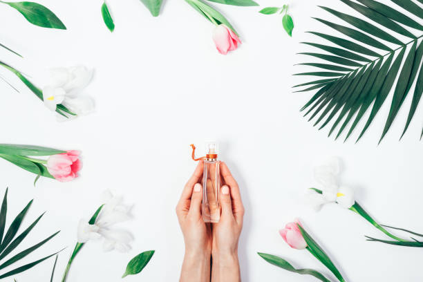 istock Perfume in female hands among flowers 940450656