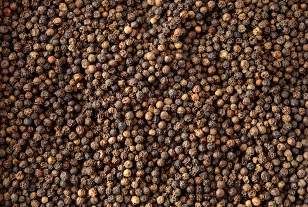 istock Peppercorn background. Dry black pepper seeds. 940451652