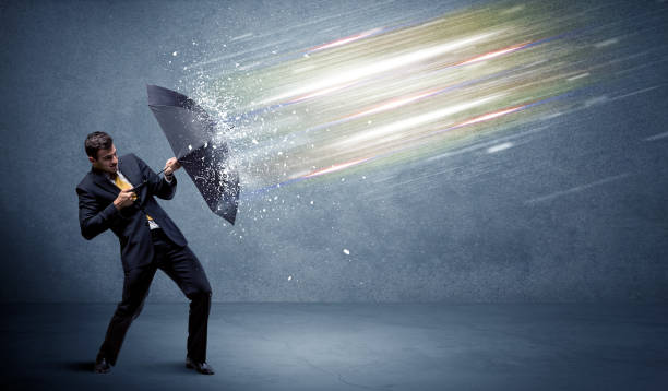 istock Business man defending light beams with umbrella concept 940451846