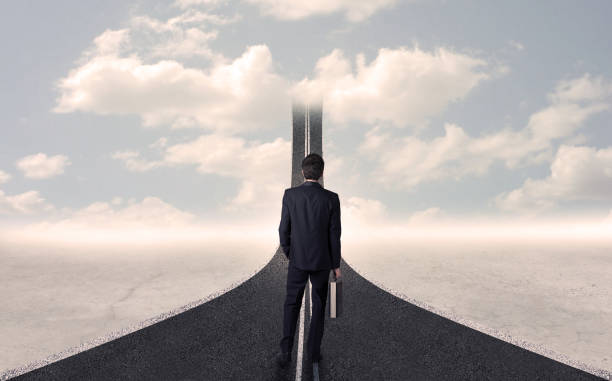 istock Businessman looking at 3d road that goes up in the sky 940458152