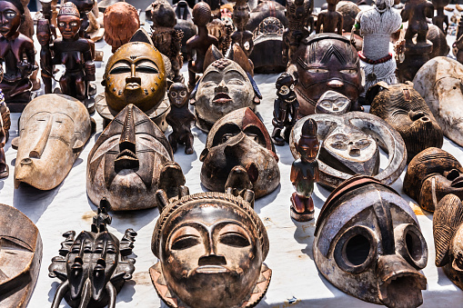 Various interesting wooden masks and figures of African culture on sale at the flea market in Paris. France