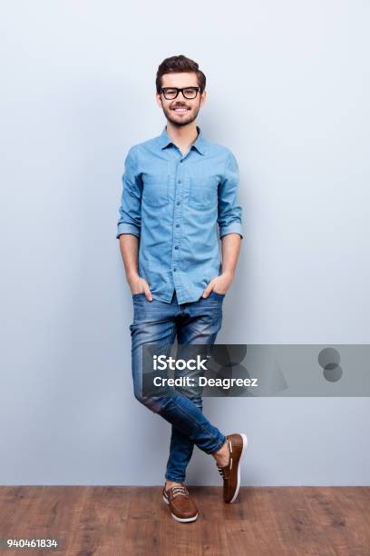 Full Size Vertical Portrait Of Cheerful Brunet Young Man In Casual Stylish Wear He Looks At Camera On Lifgt Background Stock Photo - Download Image Now